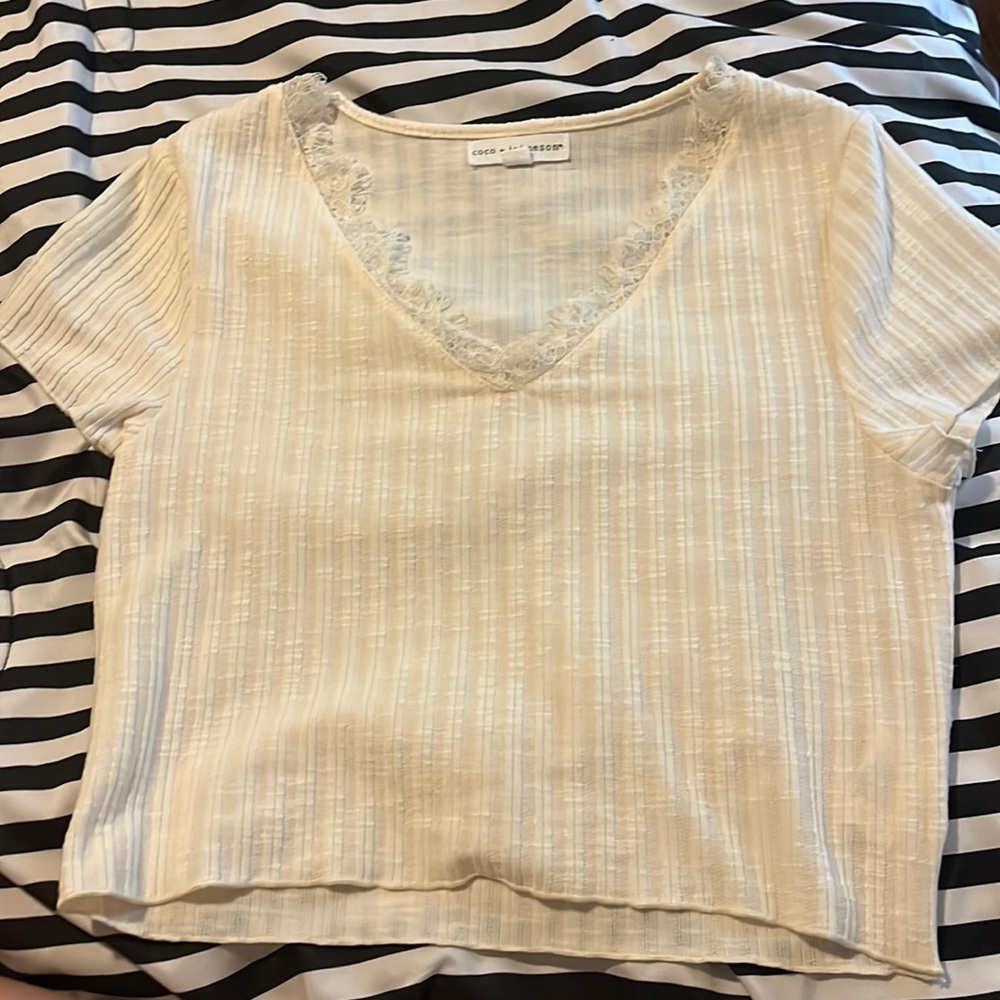 This is a white cropped dressy v neck shirt. It has really pretty lace.
